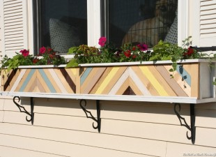 Plain white window planter box dressed up with painted scrap wood pieces in a chevron design