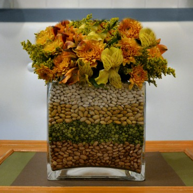 Make a simple fall flower arrangement by layering beans, lentils, peas and corn between two glass vases