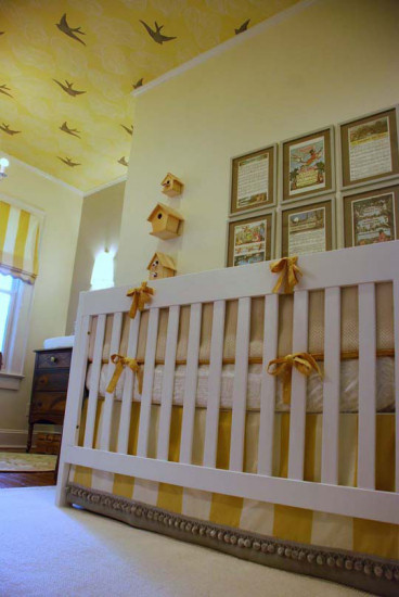 Yellow and white nursery with yellow ceiling with clouds and birds