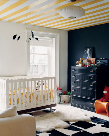 Modern nursery with black and white walls and a white and yellow striped ceiling