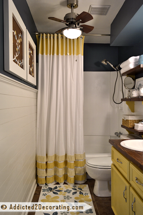 Small bathroom makeover with DIY ruffled shower curtain, open shelves, mosaic tile mirror, painted floor cloth