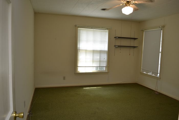 Master bedroom with original hardwood floors hidden under green carpet