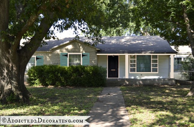 Stone house, black front door, aqua shutters