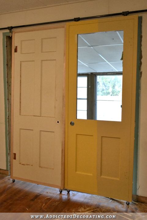 DIY rolling door painted in two shades of yellow from Behr - jackfruit on the left and warm muffin on the right