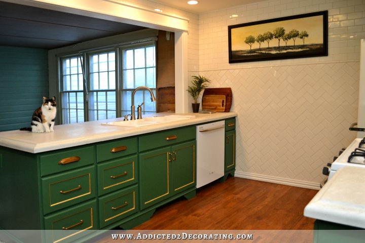 kitchen with kelly green cabinets, herringbone subway tile on walls, and white concrete countertops
