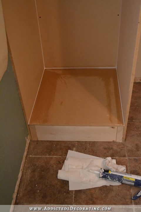 DIY cabinet style bedside closet - cover the base with MDF, glue and nail down, and then caulk the joints