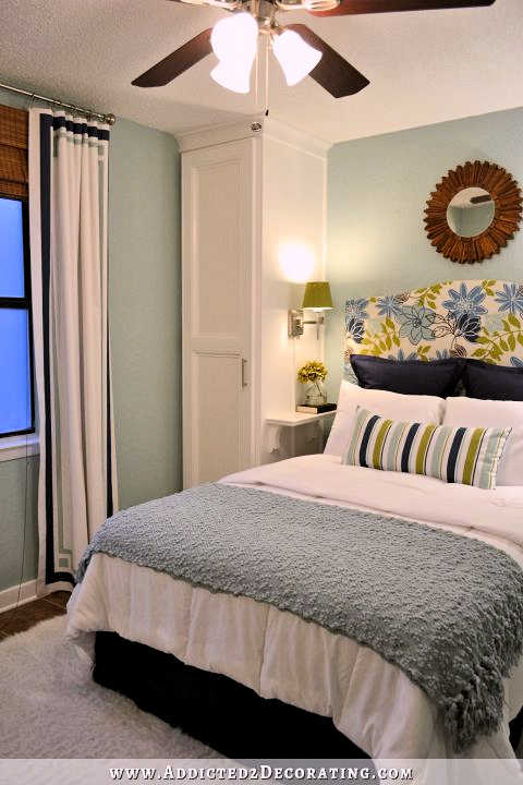 Small condo bedroom makeover with built-in bedside closets, upholstered headboard, and cheap curtains with painted accents