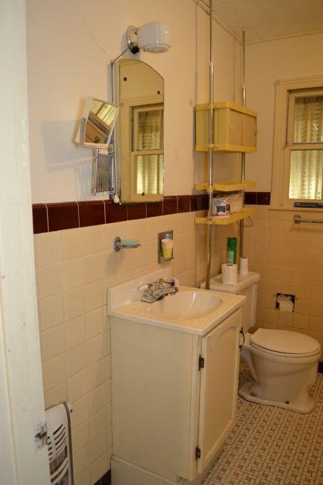 Outdated bathroom from late 1940s / early 1950s with mosaic tile floor and tiled walls