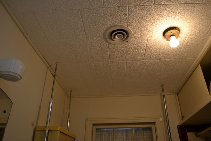 bathroom ceiling covered in acoustic polystyrene (styrofoam) tiles, probably added in the 1970s