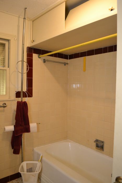 original tiled bathtub surround above cast iron bathtub in late 1940s / early 1950s bathroom, with storage above, probably added in the 1970s