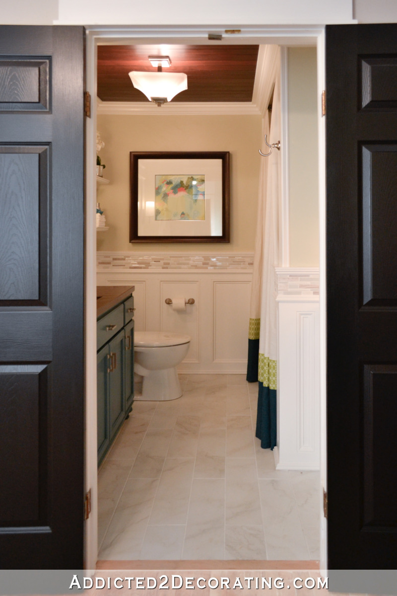 Bathroom remodel with new flooring, vanity, and wainscoting