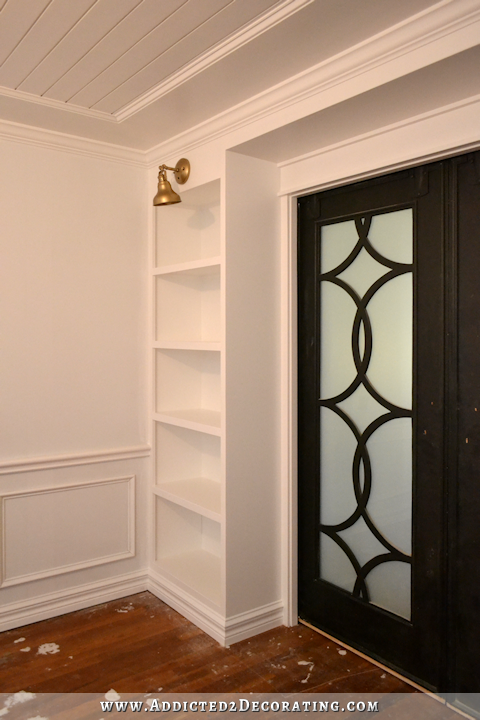 music room pocket door bookcases with brass sconces - 2