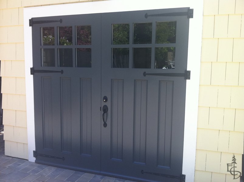 black carriage doors on yellow house with white trim, via Evergreen Carriage Doors