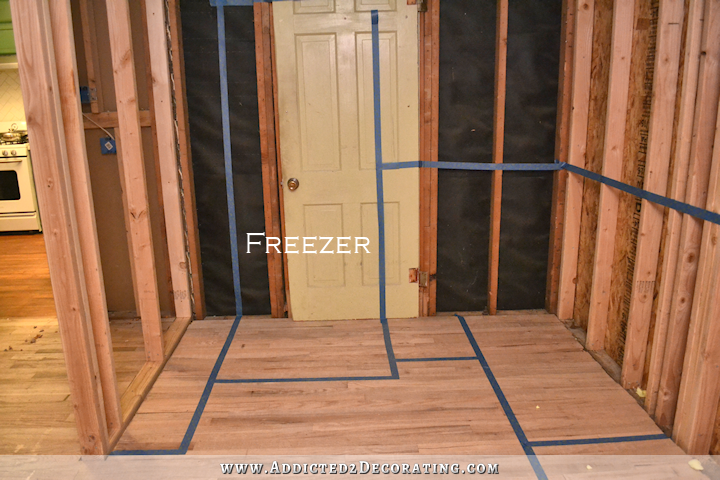 walk-in-pantry-taping-off-cabinet-layout-wtih-painters-tape-freezer-wall