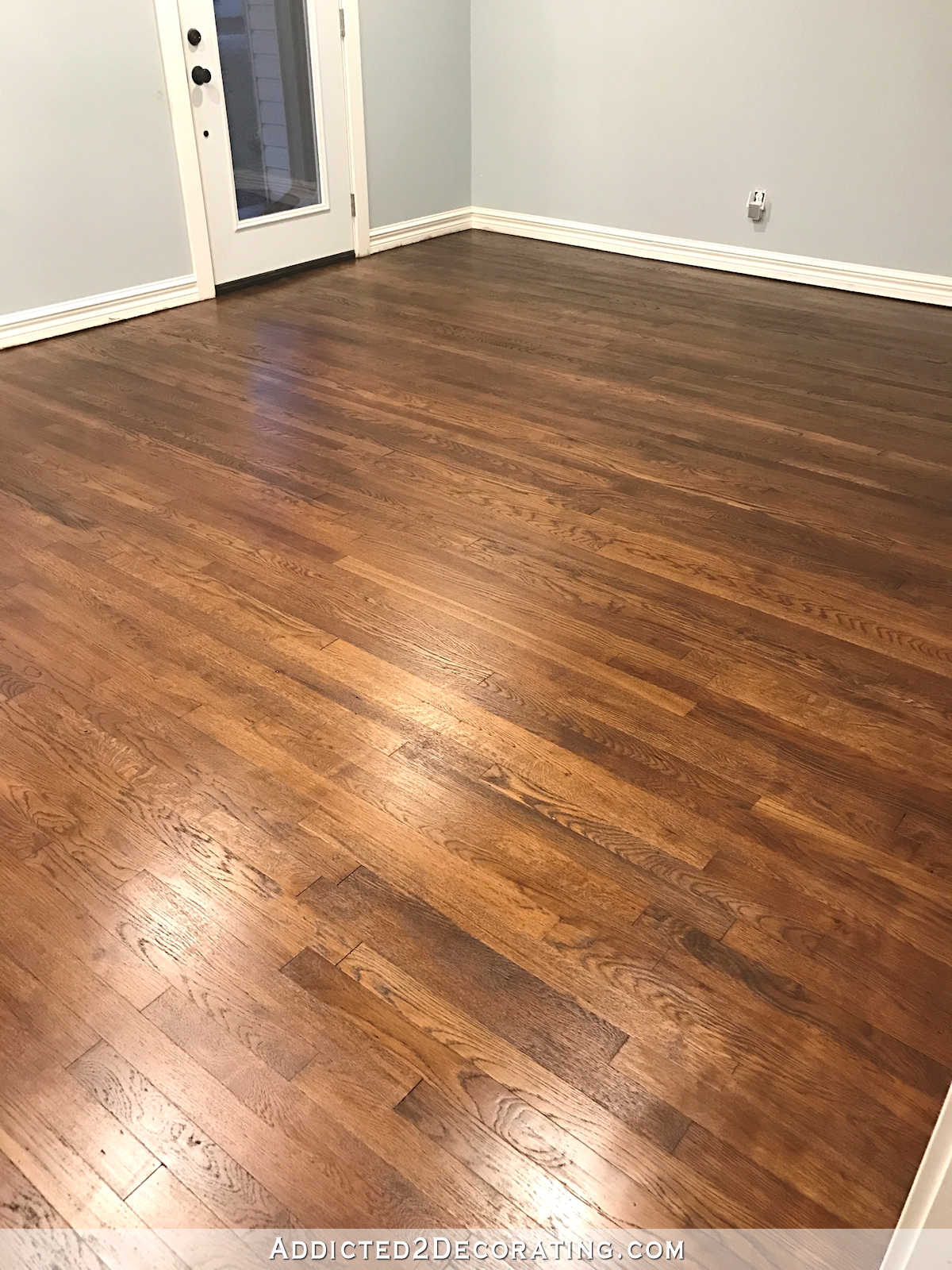 refinishing red oak hardwood floors - adding stain to first coat of polyurethane to darken the color - entryway and living room