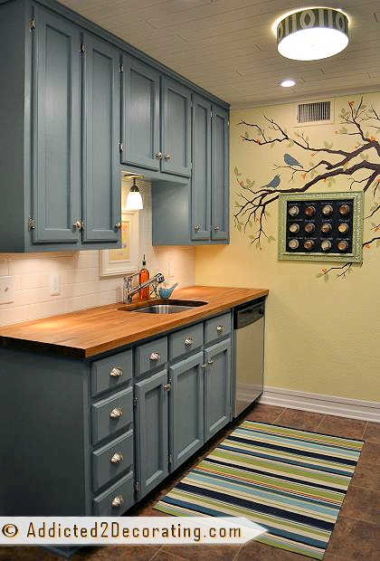 condo kitchen - teal cabinets with wood countertop