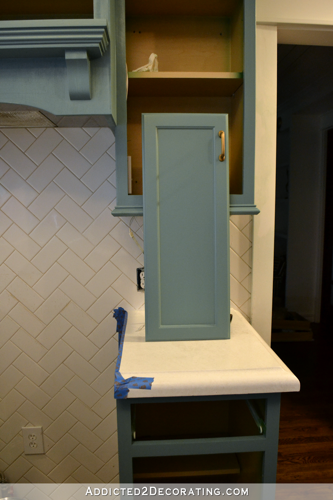 kitchen cabinet hardware - brass pulls on teal cabinets