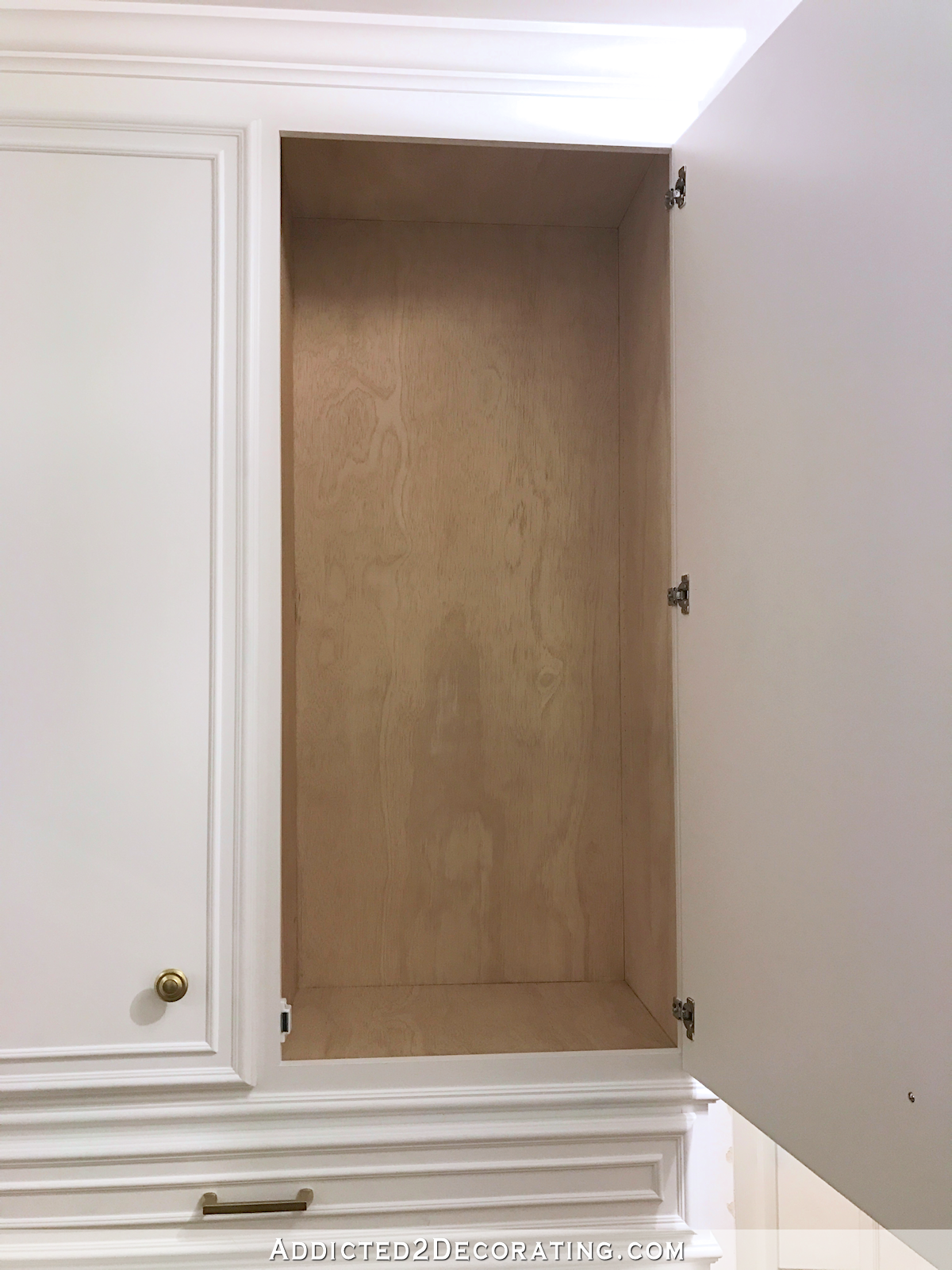 finished hallway cabinets - interior of upper cabinet with polyurethaned natural plywood - 2