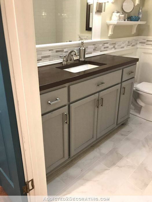 guest bathroom painted gray with stained wood countertop