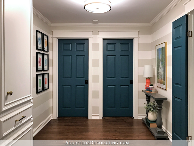 hallway after remodel - teal doors, striped walls, watercolor artwork