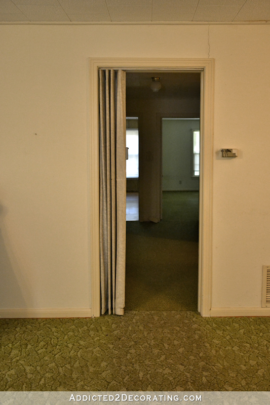 hallway before remodel - narrow cased opening into hallway, green carpet