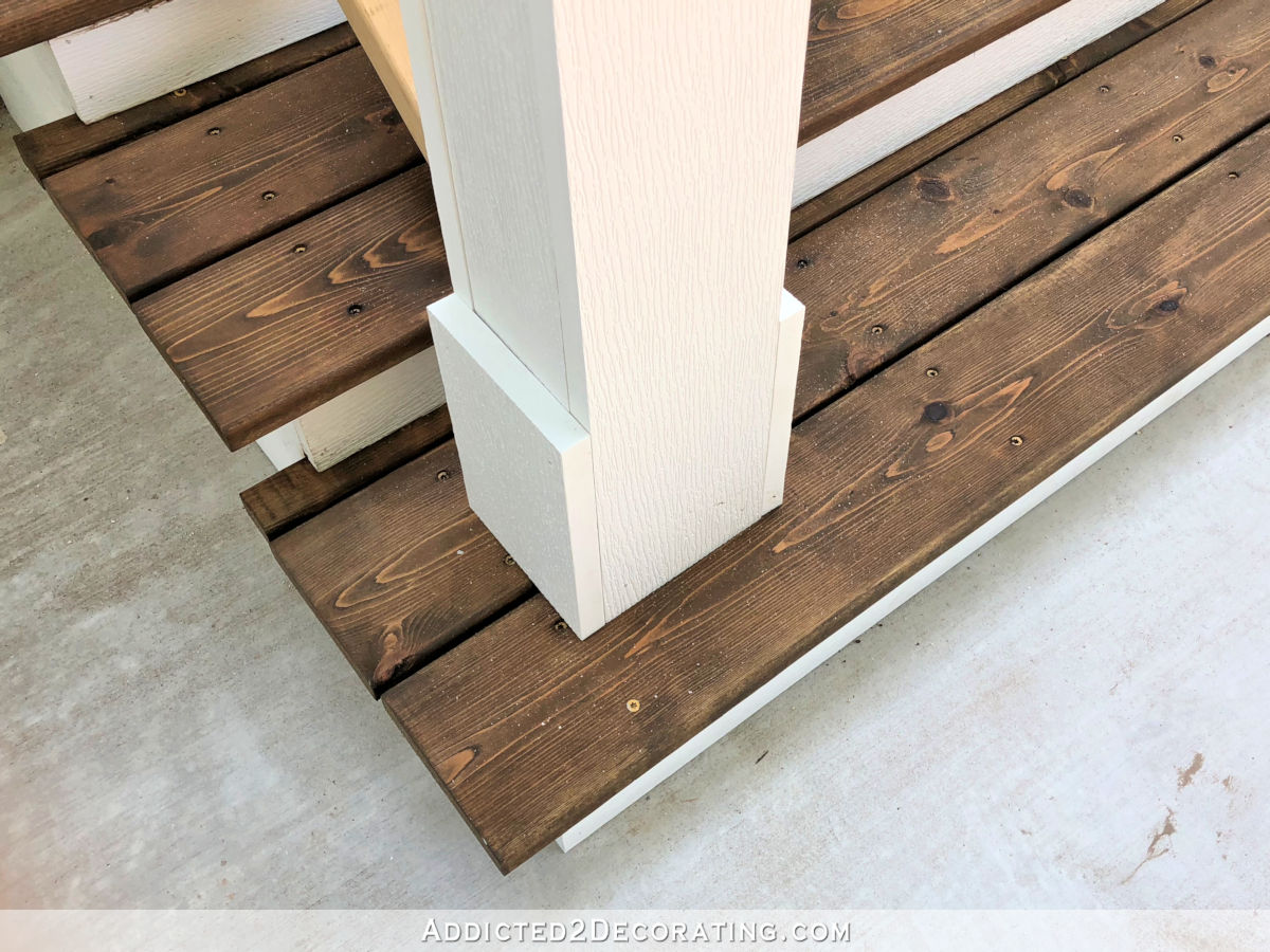 Trim pieces attached to the bottom of the handrail post to match the porch columns.