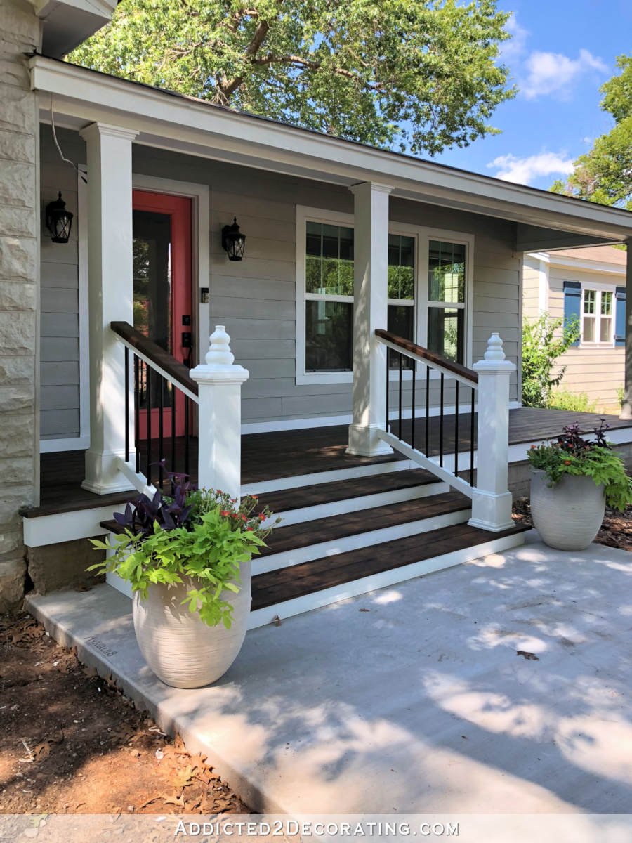 Thompson's Timber Oil in Dark Walnut used on a cedar wood front porch with white trim, light gray siding, and coral front door
