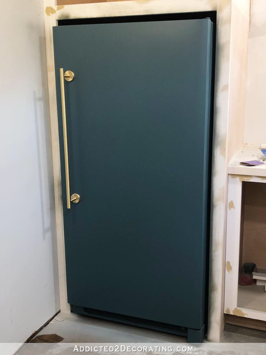 DIY painted refrigerator (upright freezer) painted a dark teal color with a new brass handle.