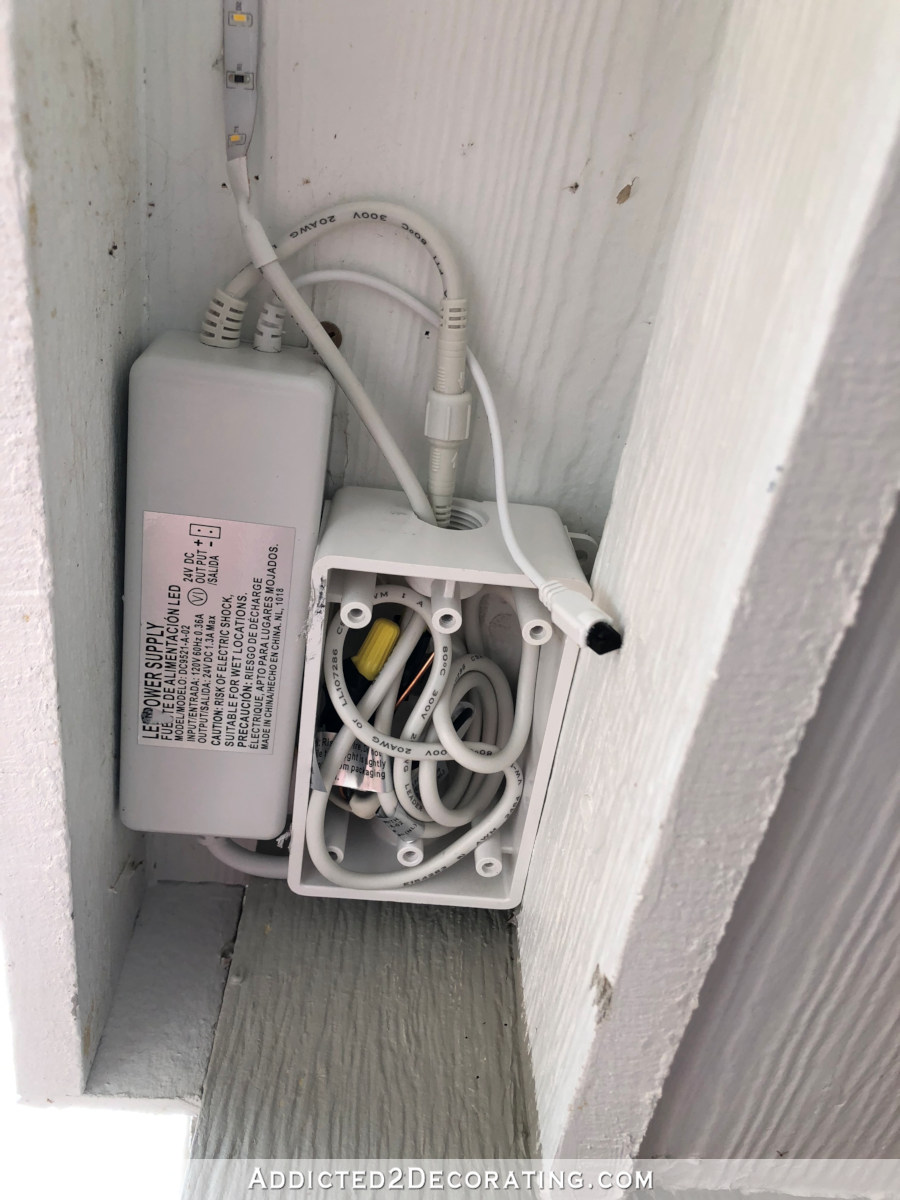 LED tape lights outdoors - installing LED tape lights around front porch roof - excess wire placed inside junction box
