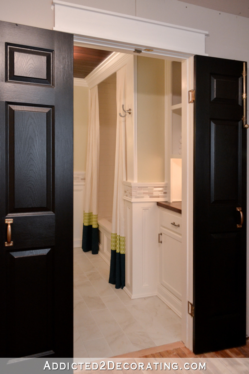 Bathtub area in remodeled bathroom with wood tub skirt and subway tile