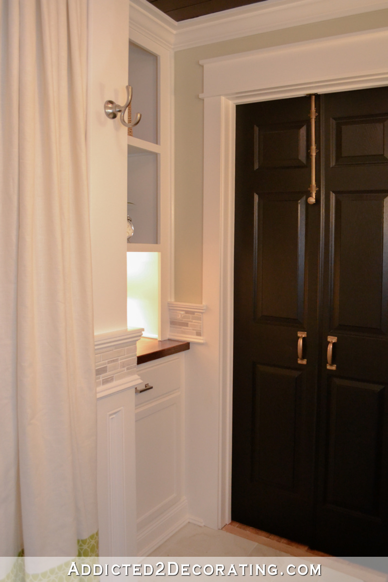 Original bathroom door replaced with double doors that open out into the hallway to make more room inside bathroom