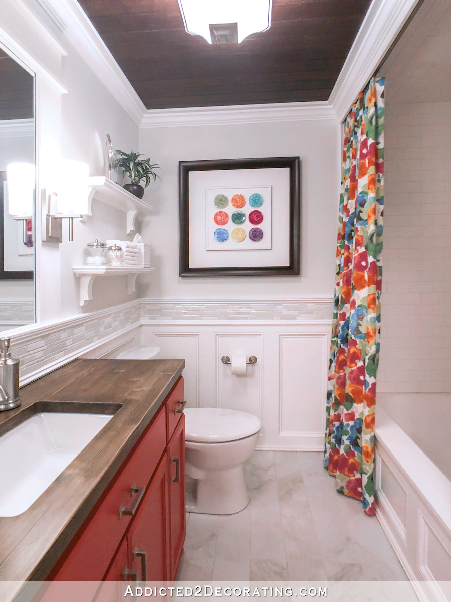 colorful small bathroom makeover with coral vanity and floral shower curtain