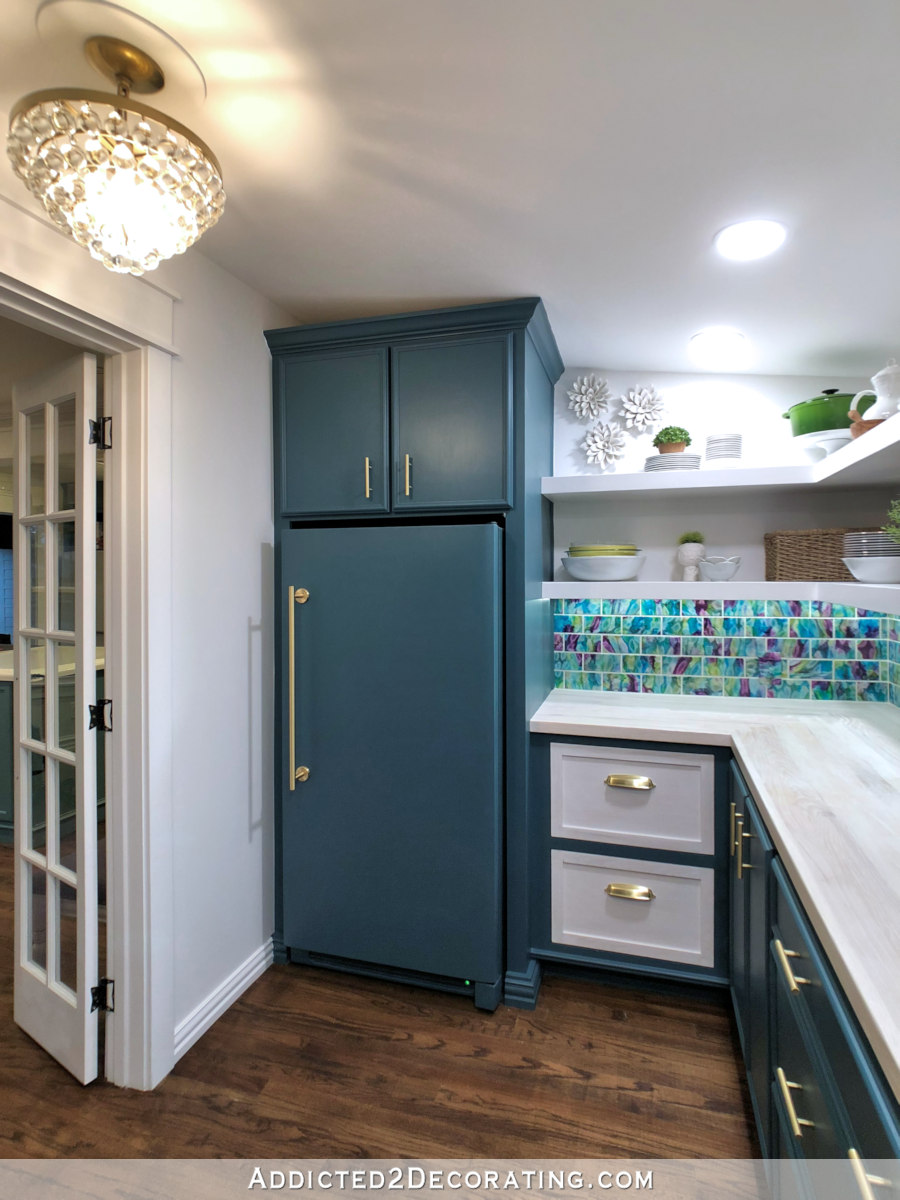 butler's pantry design with talk corner cabinet built around a custom painted upright freezer, painted dark teal