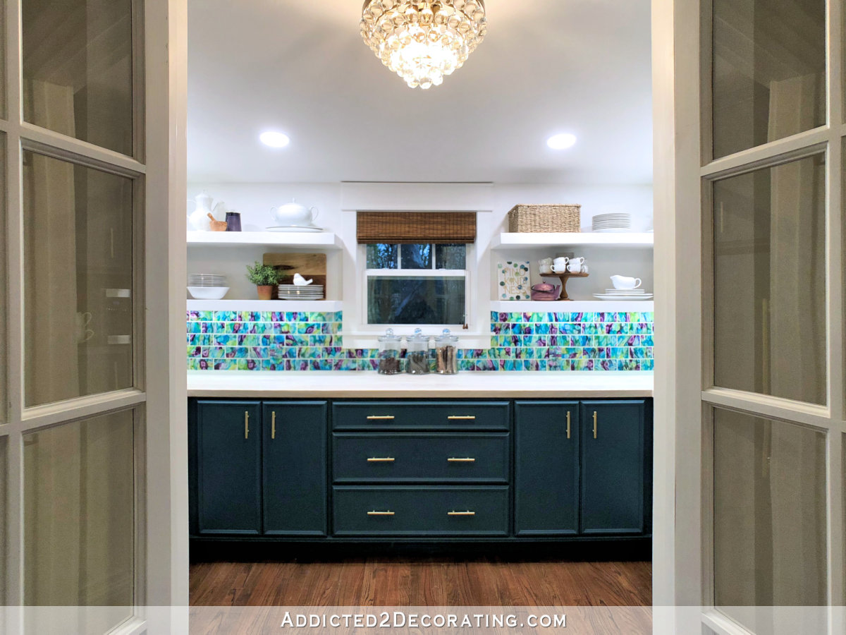 Butler's pantry design with lower cabinets, wood countertop, custom tile backsplash, and upper open shelves