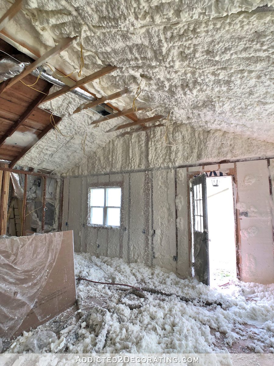 studio during spray foam insulation process - foam sprayed and being shaved on walls and vaulted ceiling