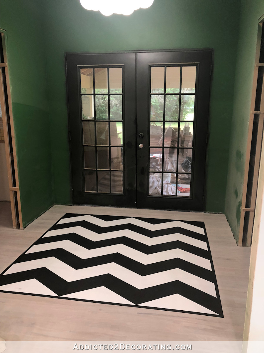 Black and white painted chevron design on hardwood flooring