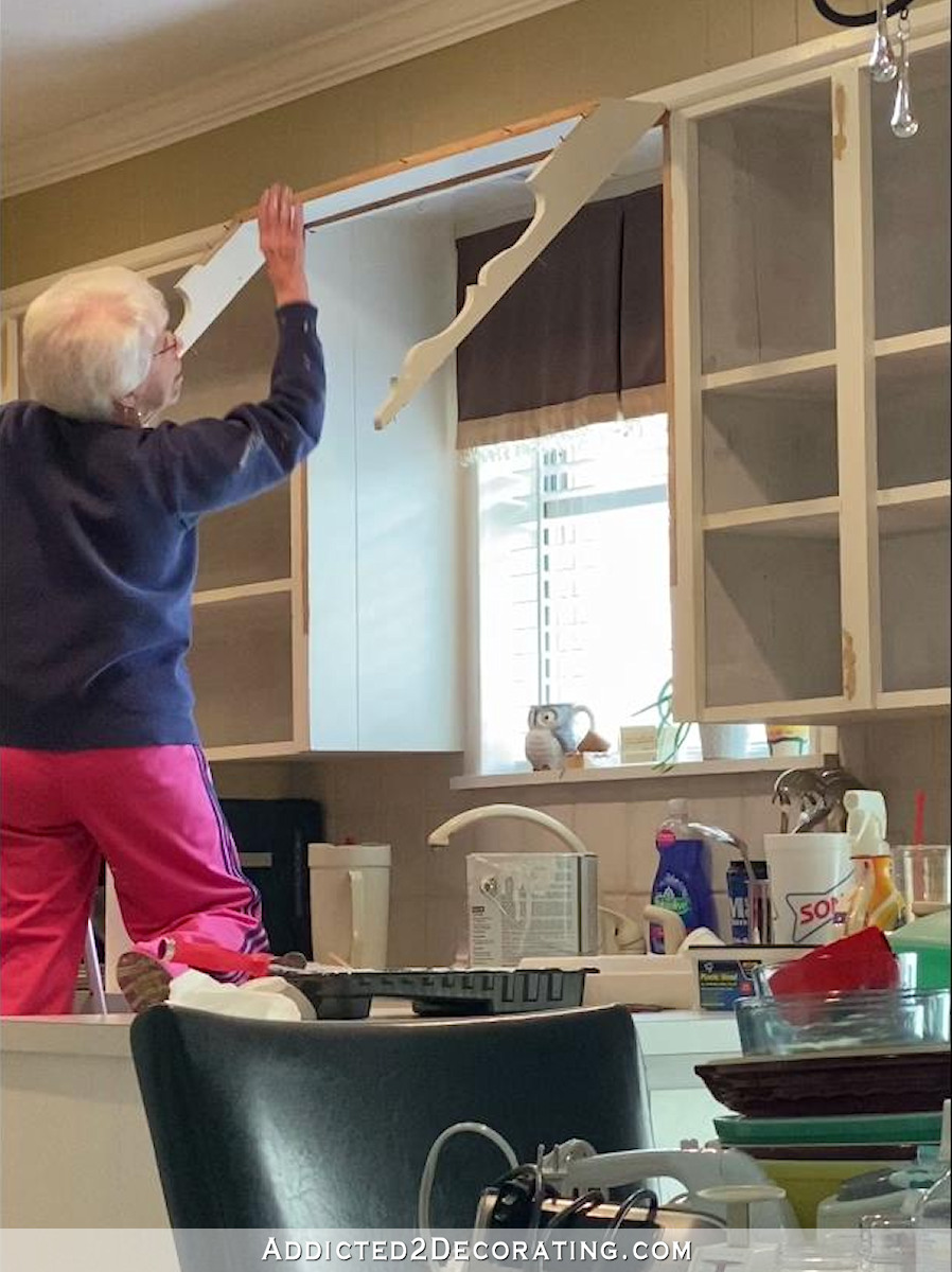 mom removing scalloped canopy over sink - 3