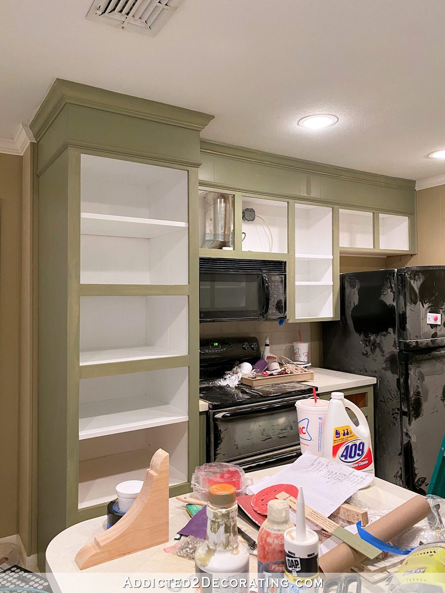 mom's kitchen makeover - first coat of paint on the cabinets - range and refrigerator wall