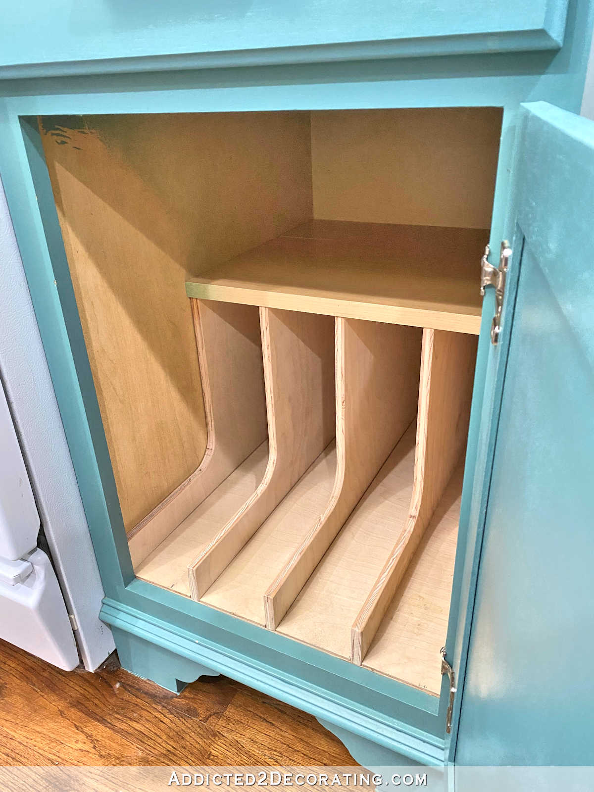 DIY skillet and lid organizer fully assembled inside kitchen cabinet