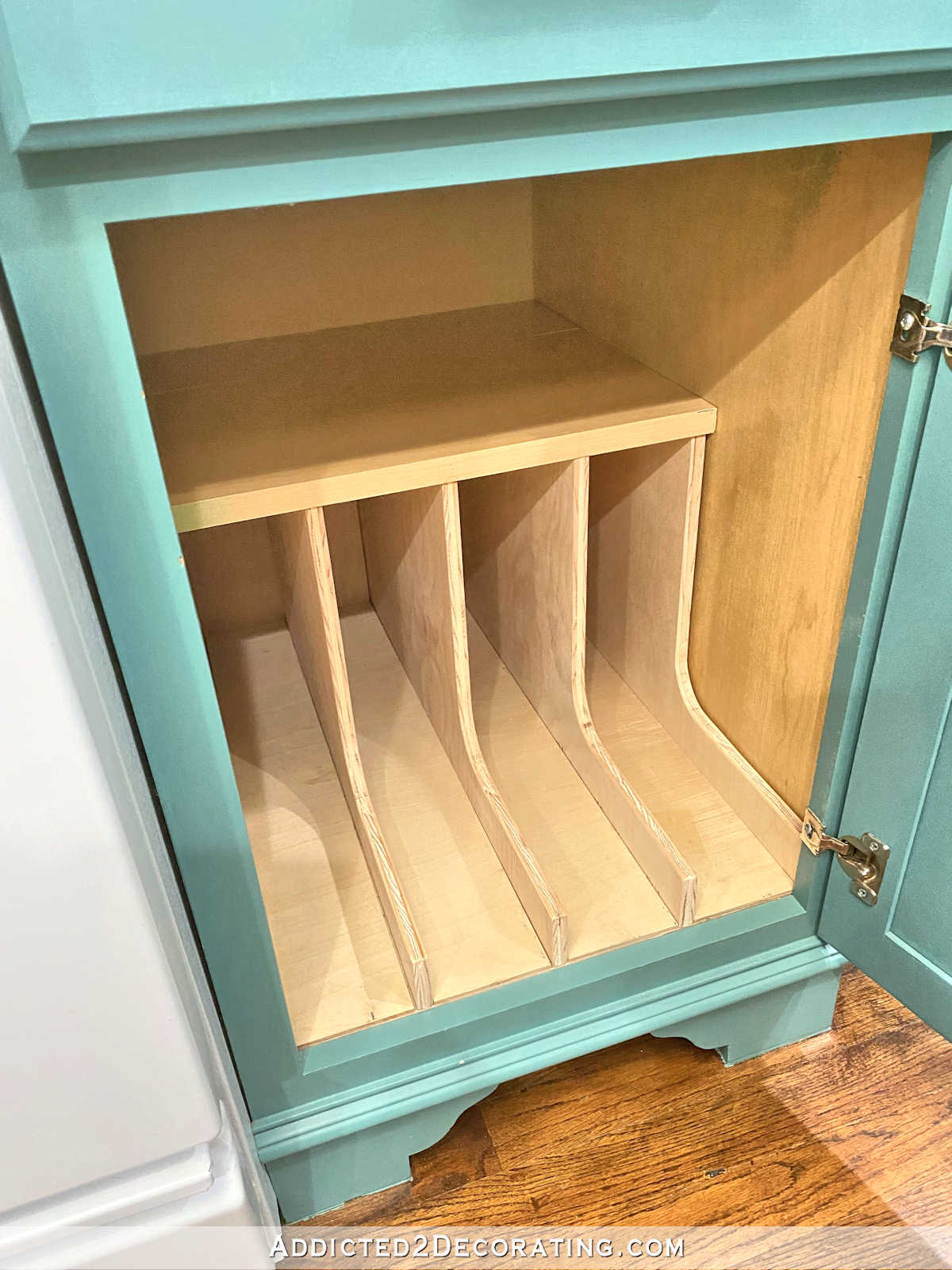 DIY pan organizer fully assembled inside kitchen cabinet