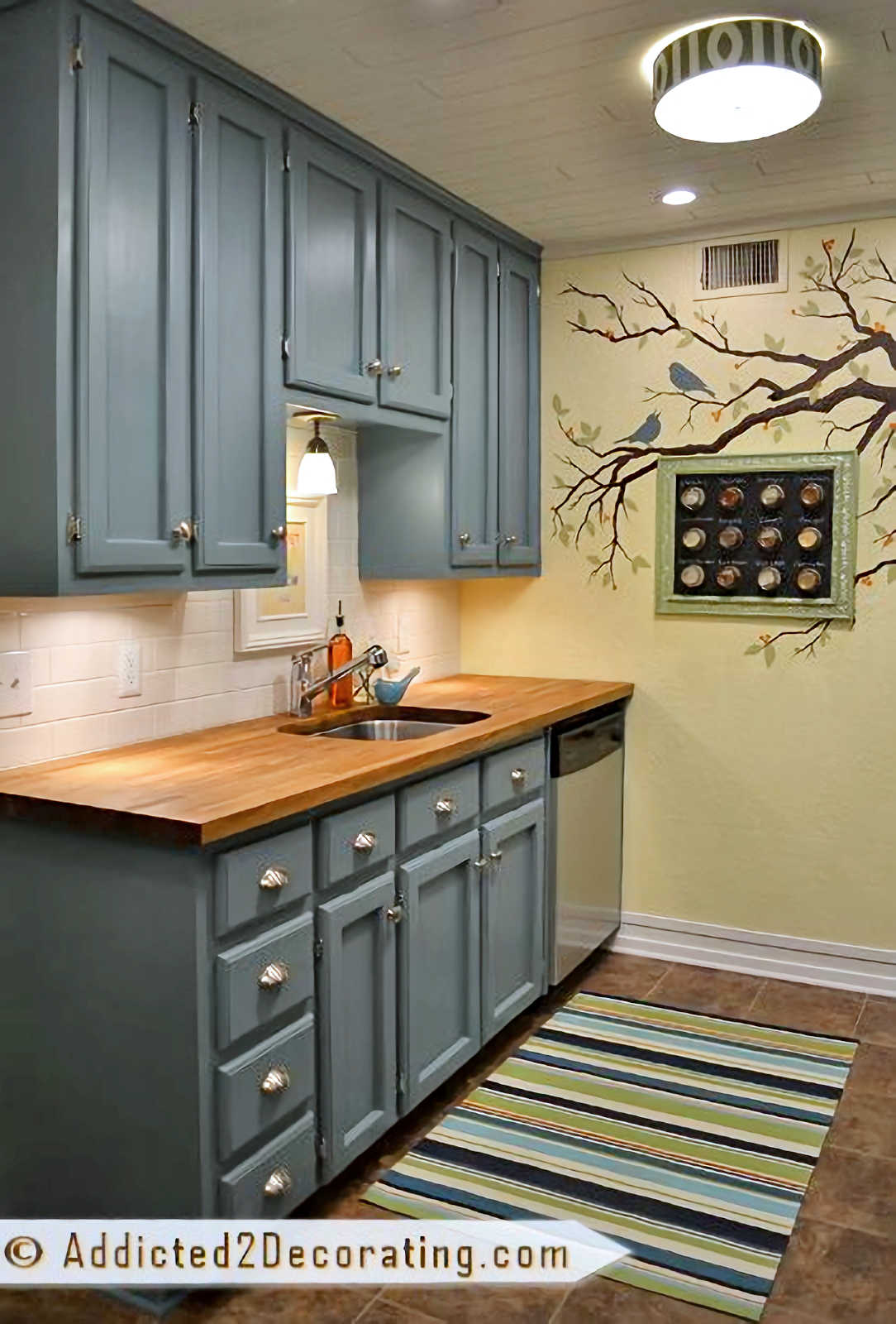tiny condo kitchen remodel - teal cabinets, butcherblock countertop, white subway tile backsplash, yellow walls