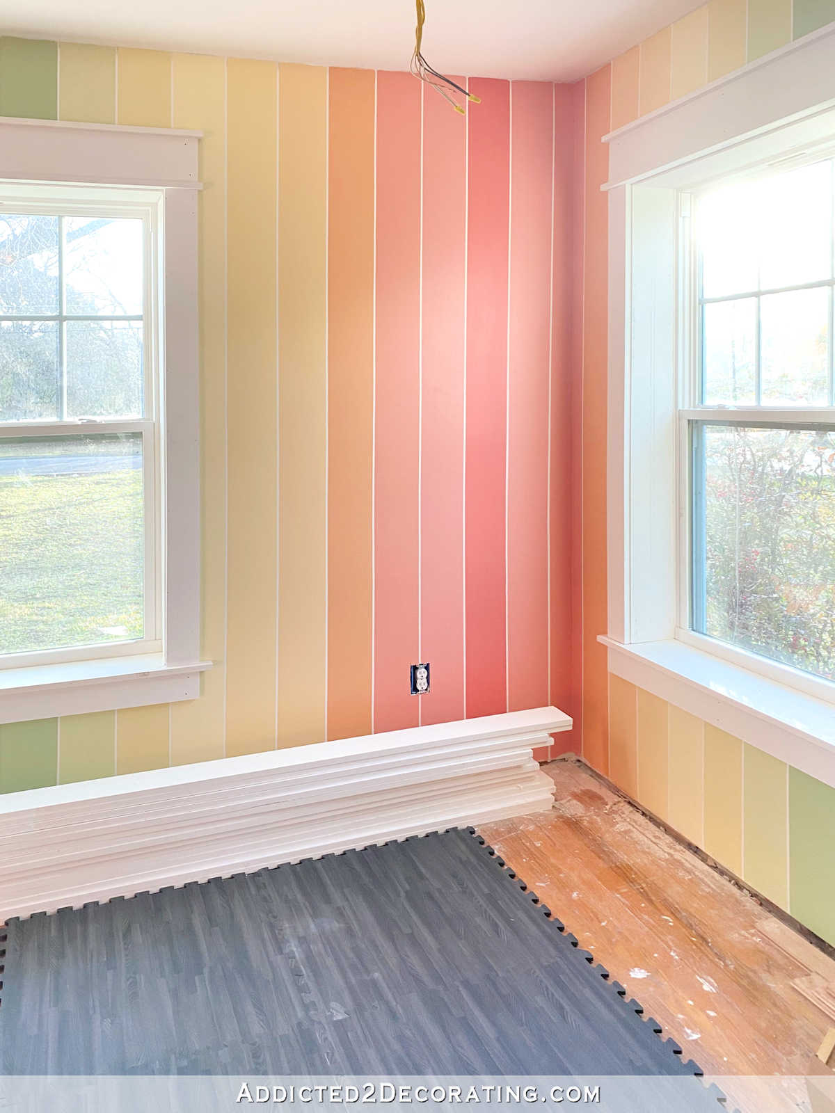 colorful rainbow stripe painted walls with black foam flooring for home gym