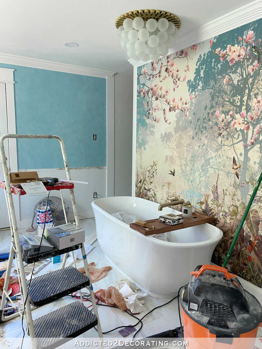 Master bathroom remodel in progress -- large wallpaper mural on wall behind bathtub, teal Venetian plaster walls