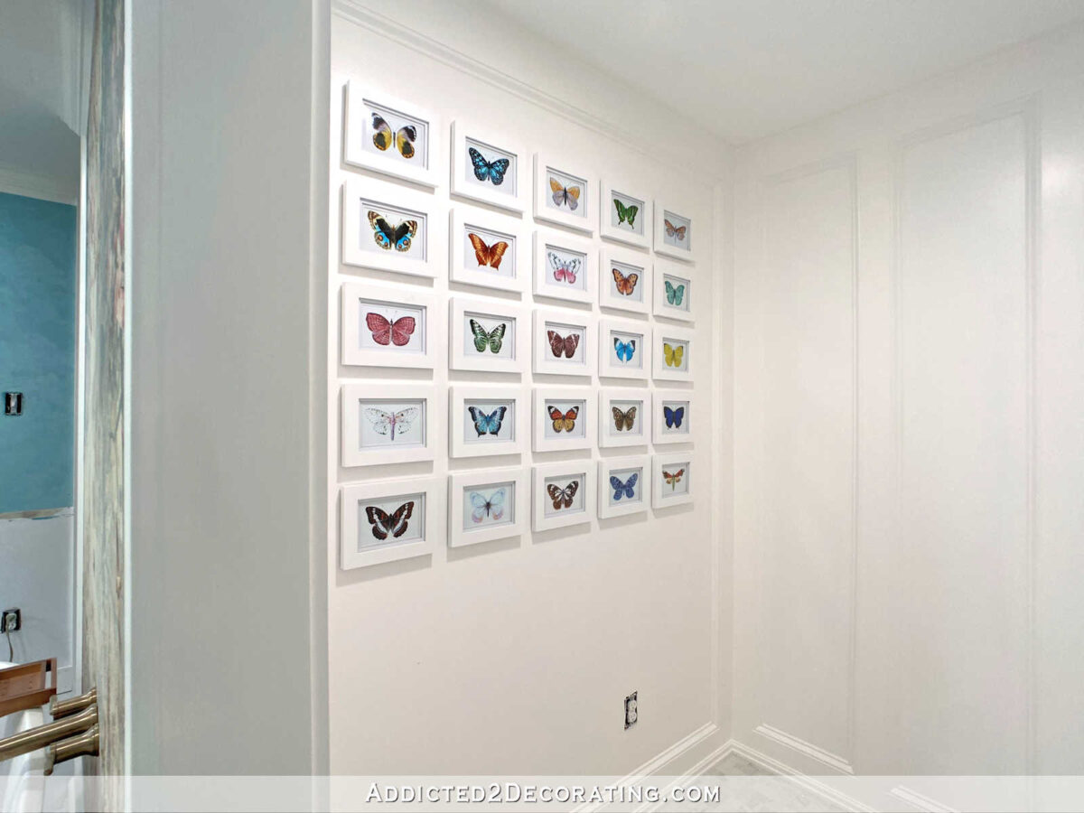 Butterfly illustrations gallery wall in the water closet area of a master bathroom
