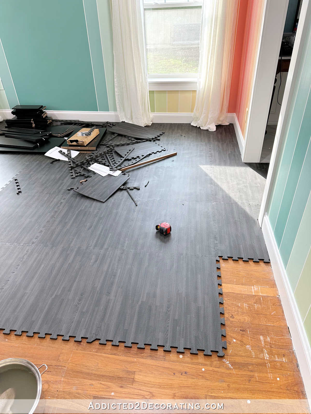 Home gym flooring -- black foam flooring with a wood grain print, called Forest Floor -- installed over hardwood floor