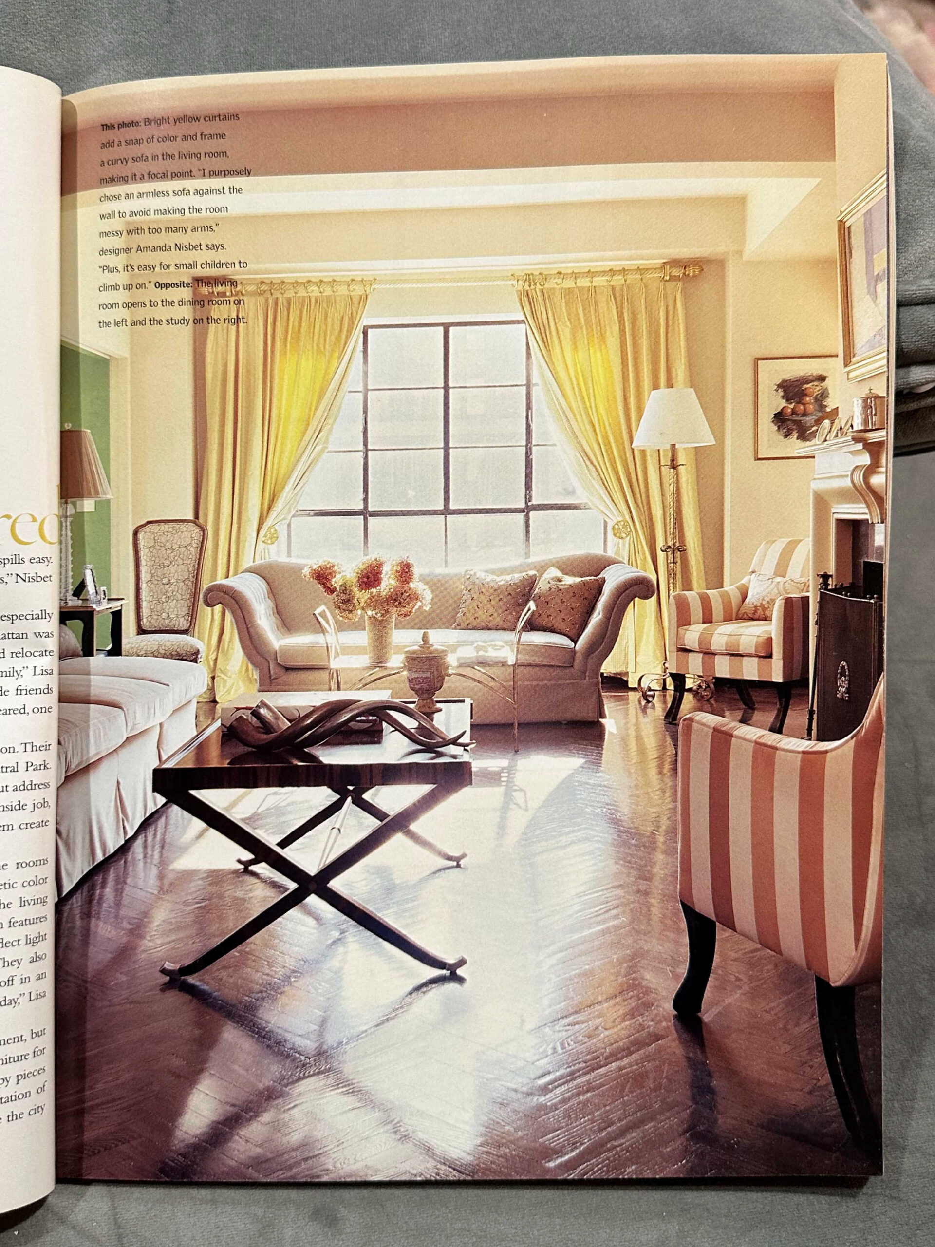 Living room with yellow curtains, neutral walls, orange and white striped chairs, white sofa, dark wood floors