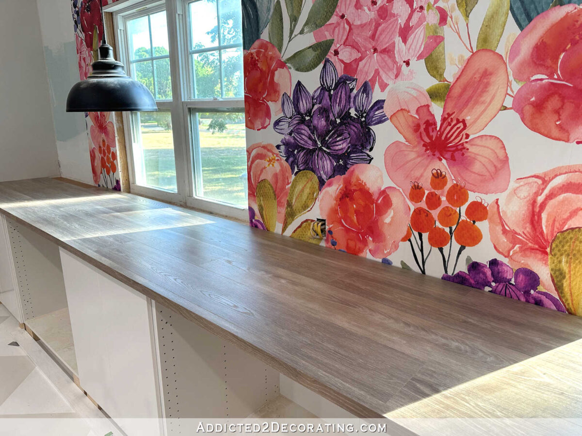 large colorful floral wallpaper mural in studio, black pendant light, DIY countertop made from laminate flooring