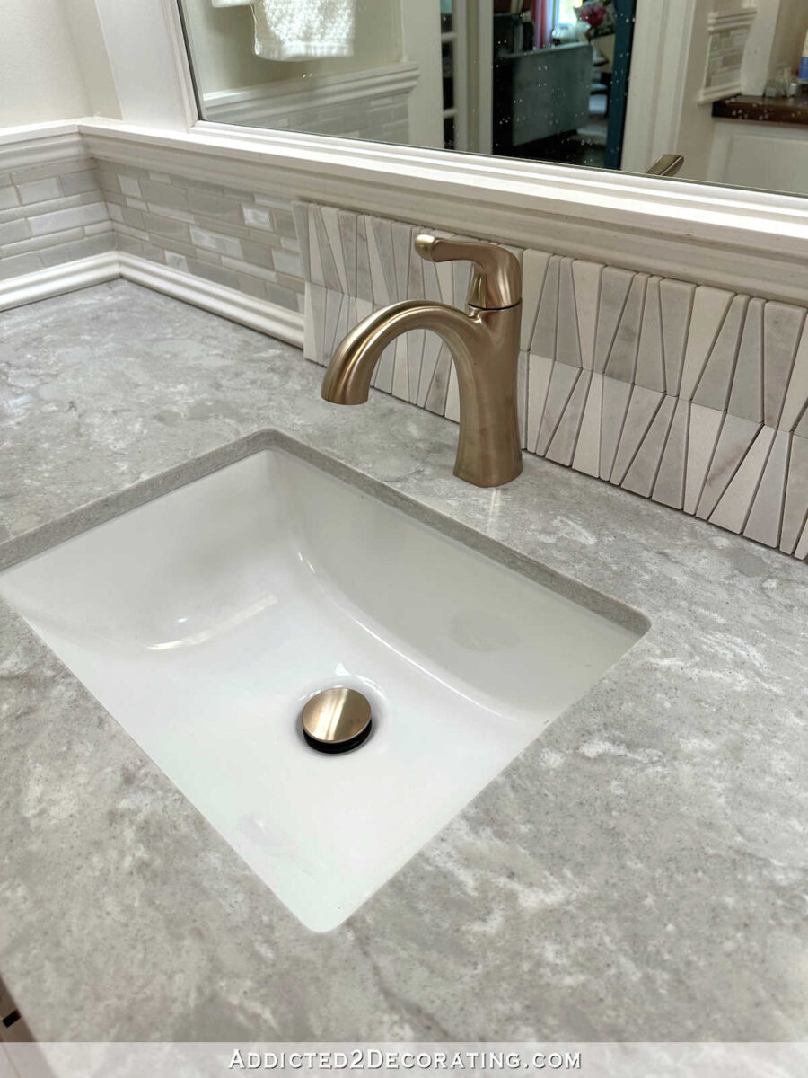 Guest bathroom mid-makeover with new Vicostone Elysian quartz countertop, new Delta Arvo single hole faucet, and potential new tile selection