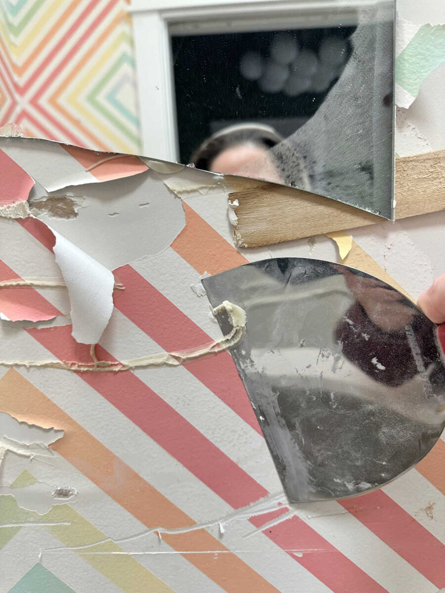 Remove mirror mastic from the wall using a heat gun and drywall mud knife as a scraper