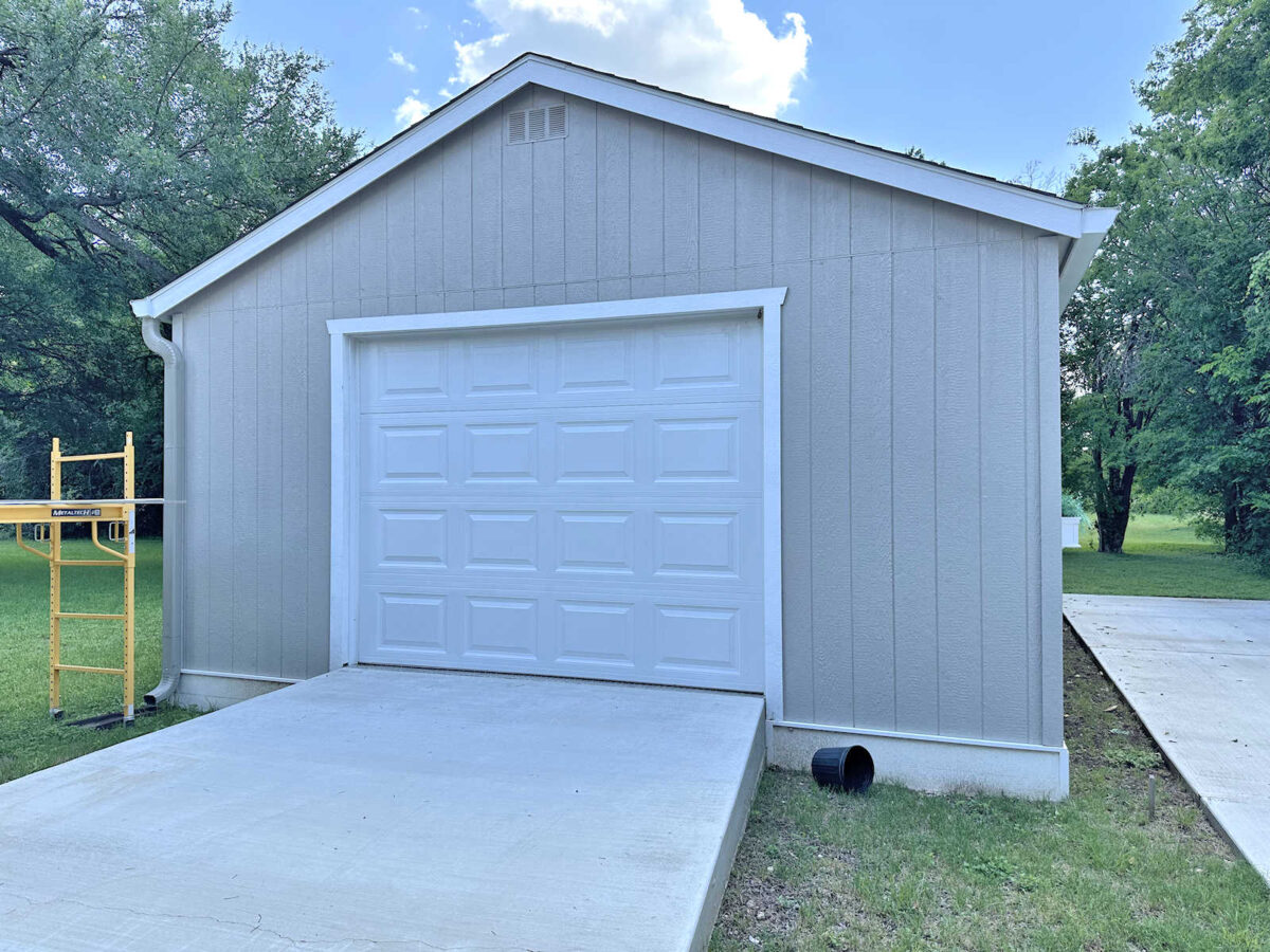 Back yard workshop exterior with a plain garage door